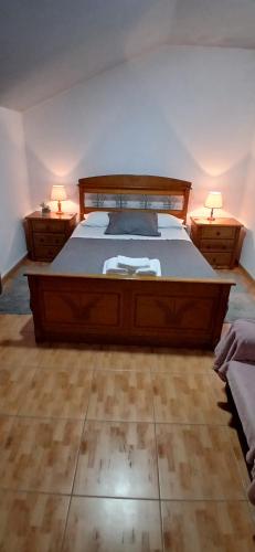a bedroom with a large bed with two night stands at Ferradosa GuestHouse in São João da Pesqueira