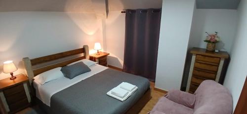 a small bedroom with a bed and a chair at Ferradosa GuestHouse in São João da Pesqueira