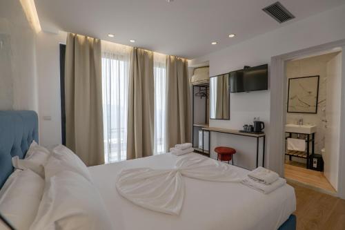 a bedroom with a white bed and a sink at Art Hotel in Sarandë