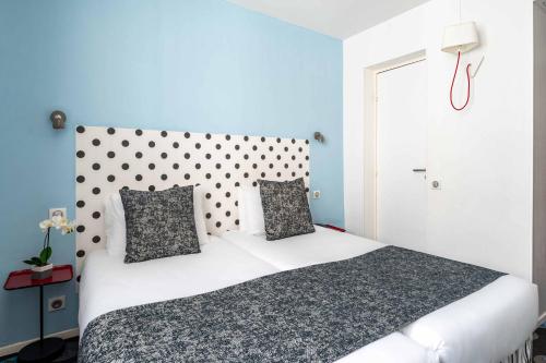 a bedroom with a large white bed with blue walls at Hotel Astoria - Astotel in Paris