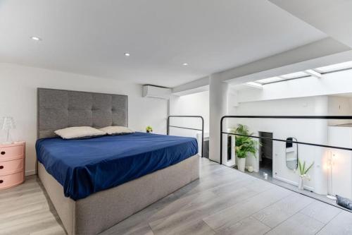 une chambre avec un grand lit avec une couverture bleue dans l'établissement Magnifique loft au cœur de Nice, à Nice