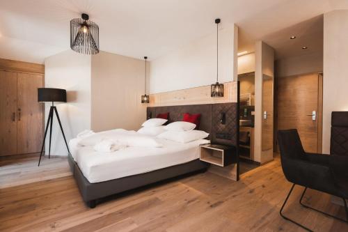 a bedroom with a large bed with white pillows at Hotel Riederhof- Urlaub mit WAU! in Ried im Oberinntal