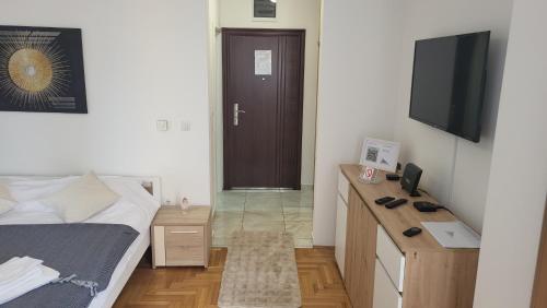 a bedroom with a bed and a desk and a television at MD dream in Novi Sad