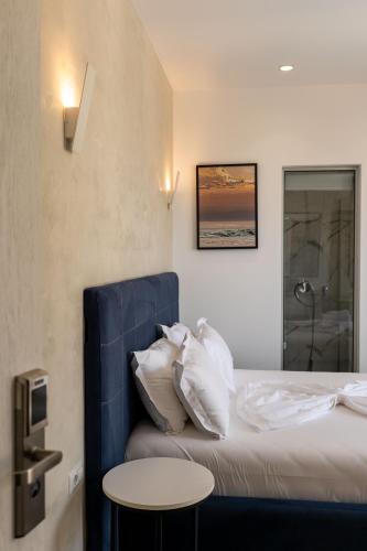 a bedroom with a bed with a blue headboard and a table at Art Hotel in Sarandë