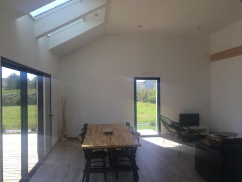 Cette grande chambre dispose d'une table et de chaises en bois. dans l'établissement Maison moderne de plain pied, à Ploudalmézeau