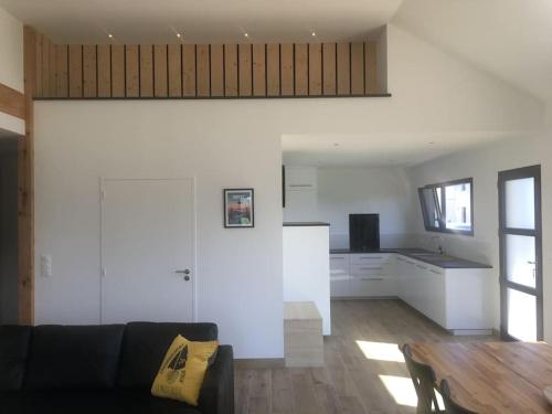 un salon avec un canapé et une cuisine dans l'établissement Maison moderne de plain pied, à Ploudalmézeau