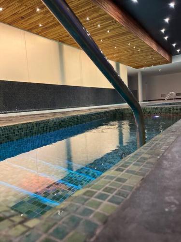 a swimming pool in a building with a swimming pool at Departamento de Lujo in Jurica