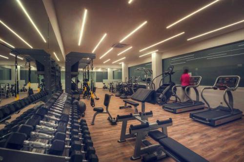 a gym with lots of exercise equipment and a woman at Departamento de Lujo in Jurica