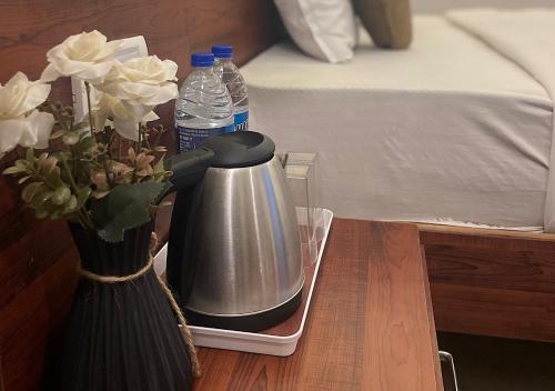 a tea kettle and a vase of flowers and water bottles at Baga Vista in Baga