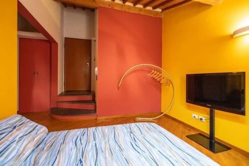 a room with a bed and a tv and a wall at 22 Home - Parcheggio privato - accogliente - collegamento Sardegna e Corsica in Livorno