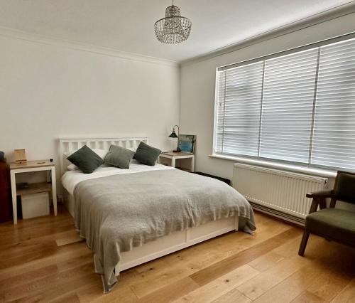 Un dormitorio con una cama y una silla y una ventana. en Seafront Medina, en Brighton & Hove