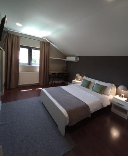a bedroom with a large white bed and a window at Vila Gosen in Şard