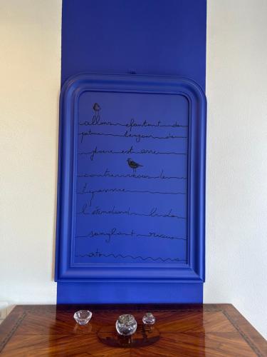 a blue picture with birds writing on a wall at Spazio DIBA in Ortona