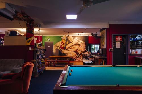 a living room with a pool table and a mural at Beachside Backpackers in Port Macquarie