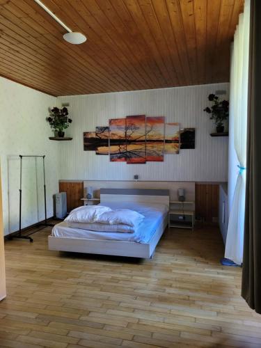 a bedroom with a bed and a wooden ceiling at Location à la ferme entre lacs et montagnes "chez papy" in Fort-du-Plasne