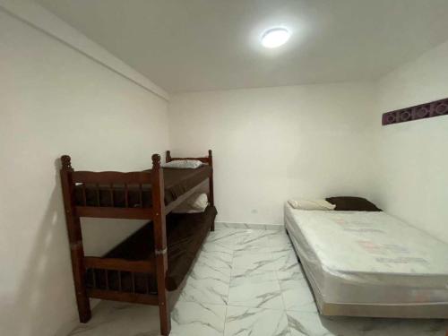 a bedroom with two bunk beds in a room at Casa com Piscina e Churrasqueira ótima localização in Praia Grande