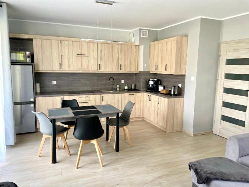 a kitchen with a table and chairs in a room at Apartament AB Villa Mountain View Szklarska Poręba in Szklarska Poręba