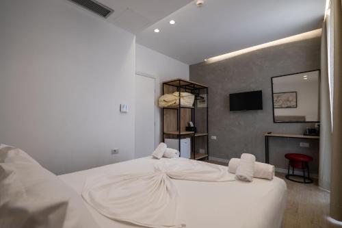 a bedroom with a white bed with two towels on it at Art Hotel in Sarandë