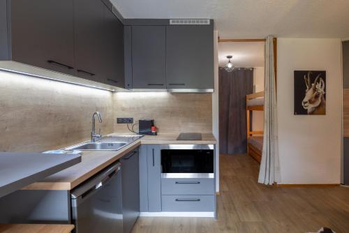 une cuisine avec un évier et un plan de travail dans l'établissement Studio haut de gamme Contamines, aux Contamines-Montjoie