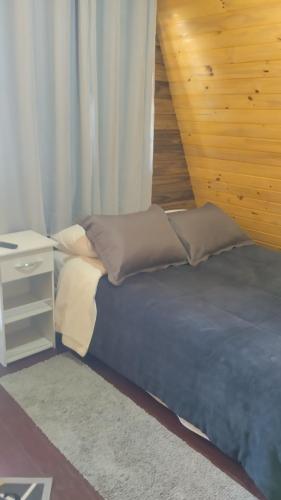 a bedroom with a bed with a nightstand and a bed sidx sidx at Sítio são longuinho in Extrema