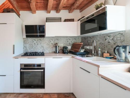 une cuisine avec des armoires blanches et un four à plaques de cuisson dans l'établissement Finca Elena - Collection Idylliq, à Gouttières