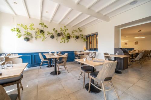 une salle à manger avec des tables et des chaises en bois dans l'établissement Hôtel Restaurant du Lauragais LOGIS DE FRANCE, à Villefranche-de-Lauragais