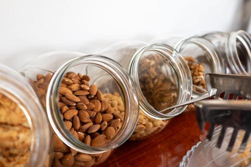 a row of glass jars filled with nuts and seeds at Art Hotel in Sarandë