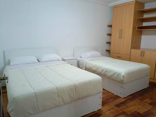 Alojamiento San Cayetano في لوخا: غرفة نوم بسريرين وكابينة