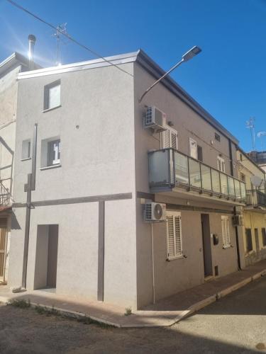 a white building with a balcony on the side of it at Piazza Salotto in Corigliano Calabro