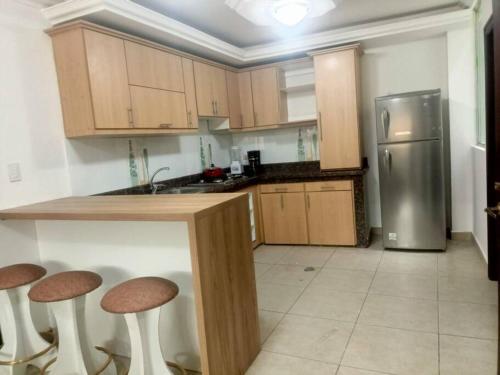 Alojamiento San Cayetano في لوخا: مطبخ مع كونتر مع الكراسي وثلاجة