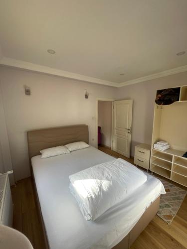 a bedroom with a large bed with white sheets at AYDER Köroğlu Apart in Ayder Yaylasi