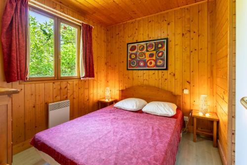 une chambre avec un lit dans une cabane en bois dans l'établissement Gite Lavande, à Mirabel-aux-Baronnies