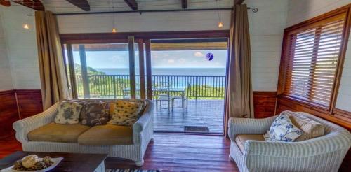a living room with two couches and a balcony at Sea La Vie Ponta do Ouro in Ponta do Ouro