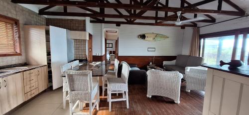 a kitchen with a table and chairs and a couch at Sea La Vie Ponta do Ouro in Ponta do Ouro