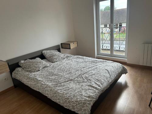 a bedroom with a bed and a large window at Maison de ville 2 chambres in Dangé