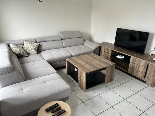 un salon avec un canapé et une télévision dans l'établissement Maison de ville 2 chambres, à Dangé