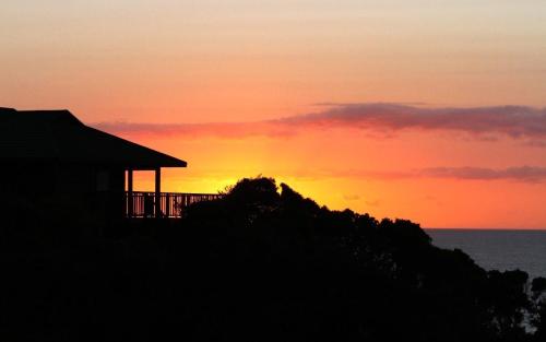 a sunset over the ocean with a house at Sea La Vie Ponta do Ouro in Ponta do Ouro