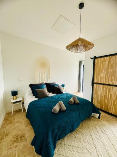 - une chambre avec un grand lit bleu et 2 serviettes dans l'établissement 