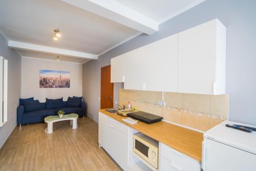 a kitchen with a blue couch in a room at Riviéra Apartmanház in Siófok
