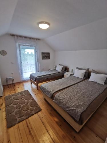 a bedroom with two beds and a window at Kuća za odmor Bella in Sotin