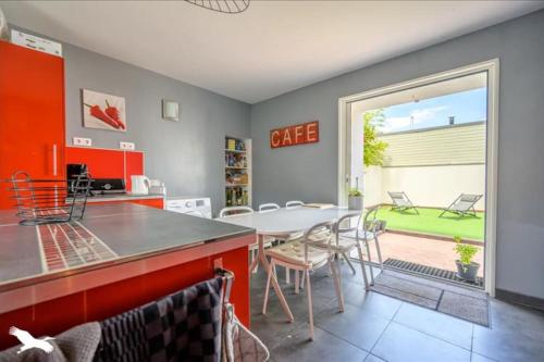 une cuisine et une salle à manger avec une table et des chaises dans l'établissement Belle maison proche plage, à La Rochelle