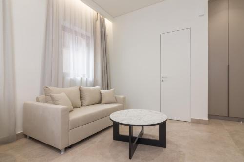 a living room with a white couch and a table at Socrates Fully Equipped Apartments with Unique Design in Athens