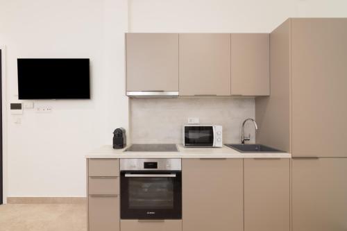 a kitchen with white cabinets and a microwave at Socrates Fully Equipped Apartments with Unique Design in Athens
