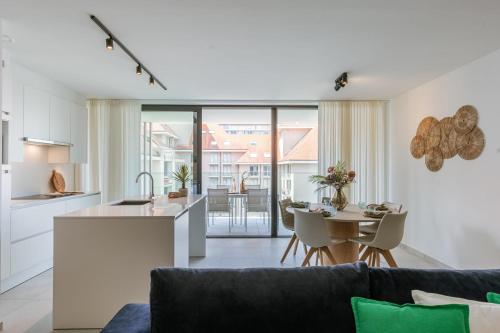 une cuisine et un salon avec un canapé et une table dans l'établissement Huswell - Apartment with Terrace in the Heart of Nieuwpoort, à Nieuport