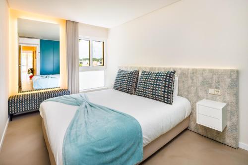 une chambre avec un grand lit et un miroir dans l'établissement Vilamoura Dream House QR2, à Quarteira