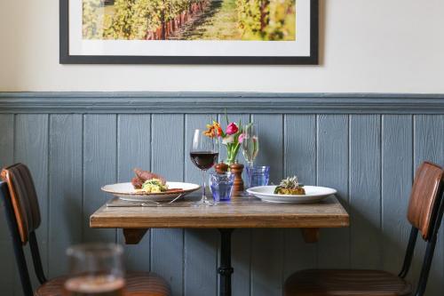 a table with two plates of food and a glass of wine at The Swan at Forest Row in Forest Row