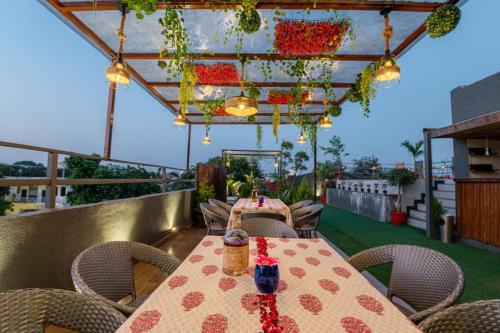 a table and chairs on a rooftop patio with flowers at Gulmohar Mansion - A Boutique Stay in Jaipur