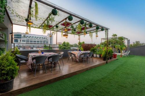 a rooftop patio with tables and chairs and plants at Gulmohar Mansion - A Boutique Stay in Jaipur