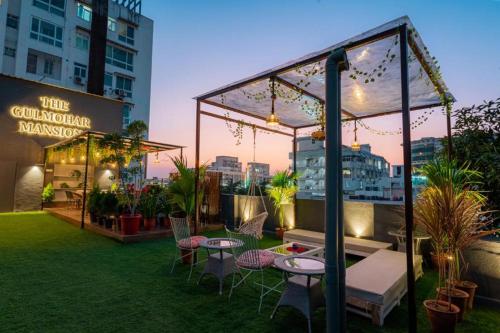 a patio with tables and chairs and a gazebo at Gulmohar Mansion - A Boutique Stay in Jaipur