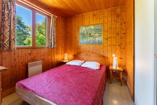 une chambre avec un lit dans une pièce en bois dans l'établissement Gite Serpolet, à Mirabel-aux-Baronnies